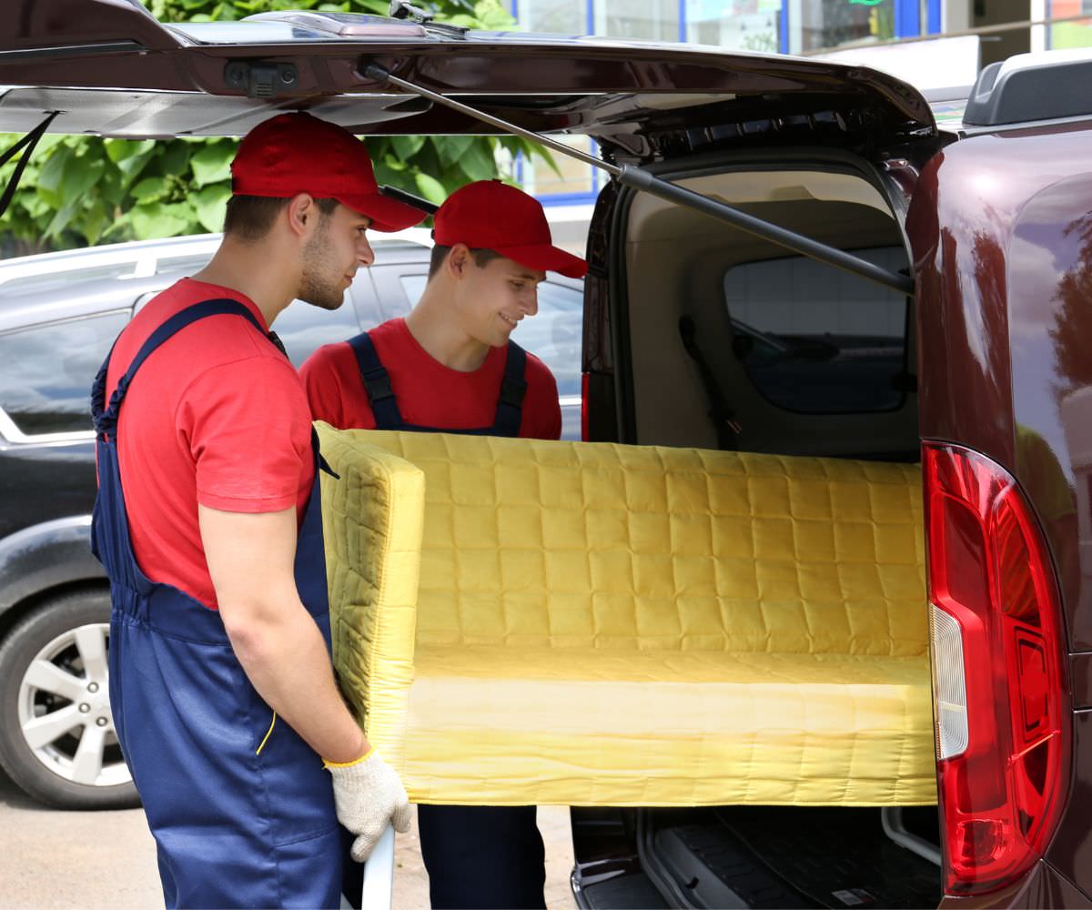 Umzugshelfer laden ein gelbes Sofa in einen Transporter – Preiswert umziehen Balingen