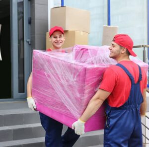 Umzug in Balingen Zwei Umzugshelfer tragen ein in Folie gepacktes Möbelstück – Umzug in Balingen