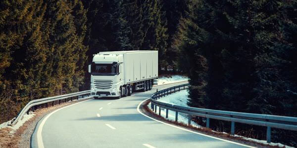 Klaviertransport Balingen: Lkw fährt auf einer kurvigen Straße durch den Wald
