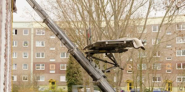 Schrägaufzug: Schräg ausgefahrener Möbellift an einem Mehrfamilienhaus