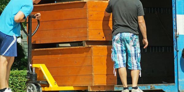 Möbellift Balingen: Zwei Helfer tragen einen Holzschrank aus einem Lkw